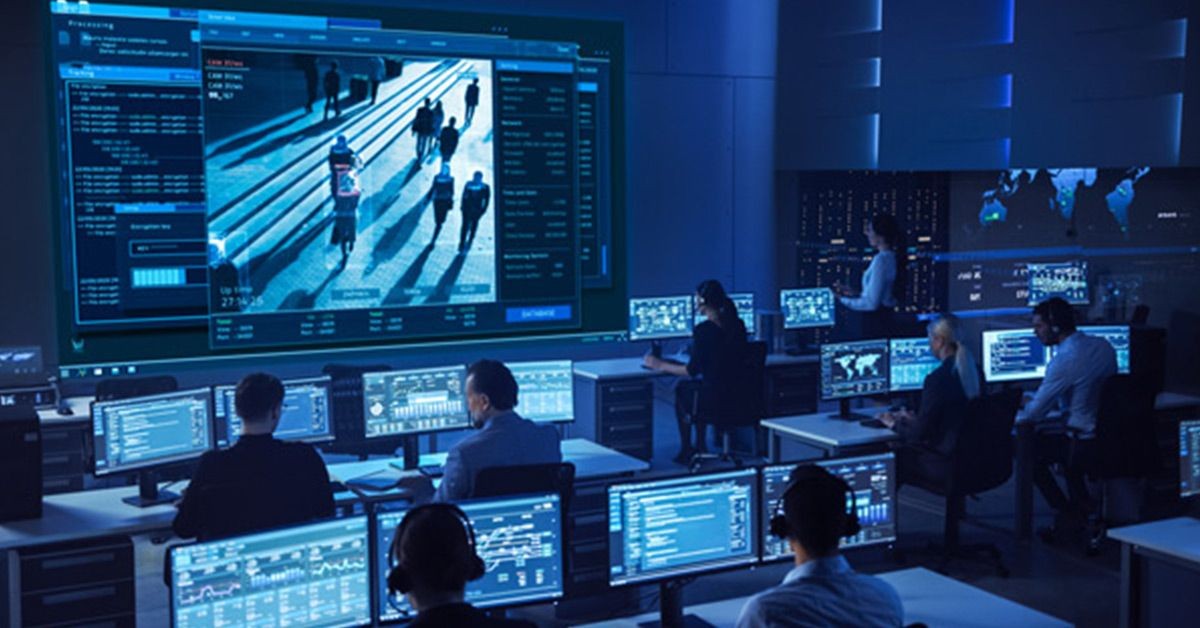 Centro de operaciones de seguridad con empleados trabajando en puestos de trabajo y un videowall que muestra el reconocimiento visual en imágenes en directo